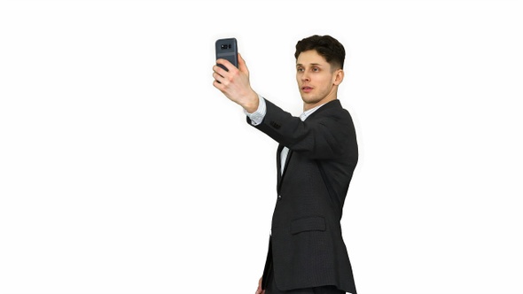 Young business man walking and taking a selfie on white background