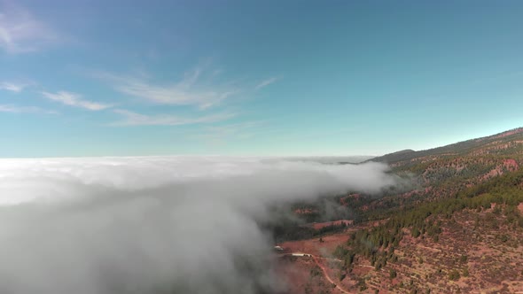 Aerial Shot. Beautiful Flight Above the Clouds Over the Red Volcanic Valley