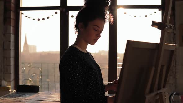 Slow Motion Footage of a Cute Female Artist in Her 20's Drawing on Easel