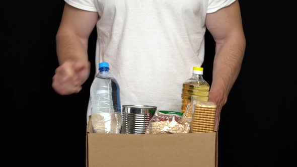 Volunteer Putting Food in a Donation Box. Charity Concept