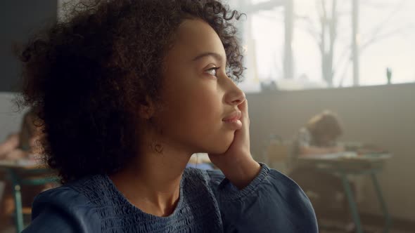 Thoughtful Pupil Sitting in Classroom