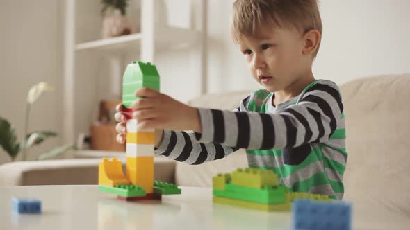 Child Playing with Colorful Building Plastic Blocks Constructor at Home