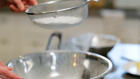 Man using sieve in kitchen at home 4k