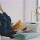 Young woman laying on couch with her legs up against the wall - VideoHive Item for Sale