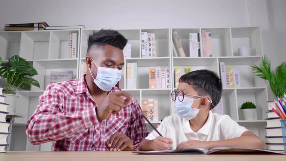 African teacher and student sitting in a room and wearing mask in private class to protect COVID19