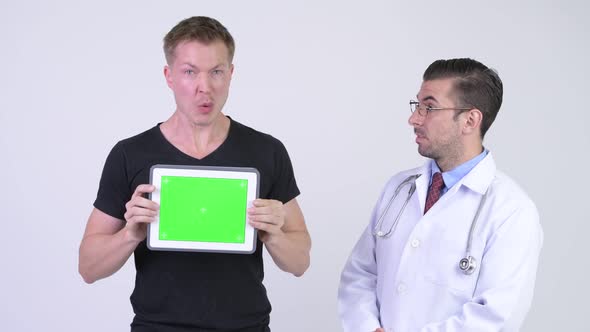 Hispanic Man Doctor with Crazy Young Patient Showing Digital Tablet