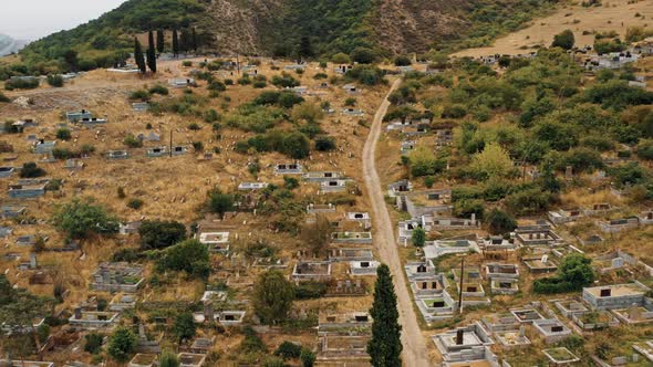 Aerial Drone Zoom Out of Cemetery, Hills and Church in Armenia, Noyemberyan