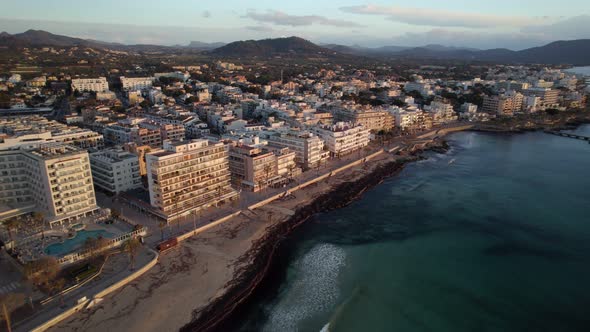 Flying along the sandy coast of a picturesque Mediterranean beachside side town