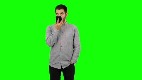 Brunette Guy Is Asking for Information on the Network Via Phone. Green Screen