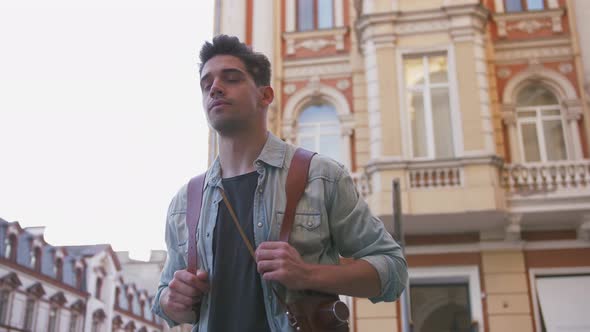 Attractive Young Handsome Man Tourist with Backpack Walking in City Center