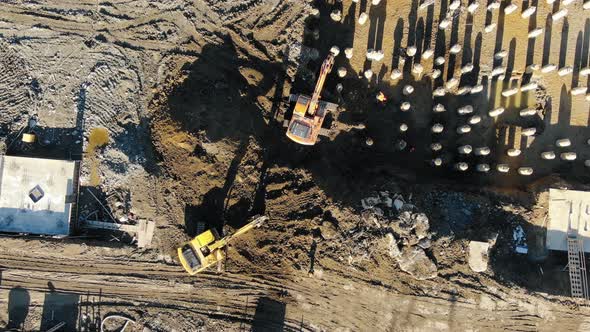 Aerial Top View Zoom Effect Excavators Digging Ground Pit for Pouring the Foundation and Laying