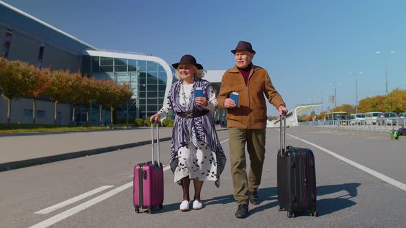 Stylish Retired Family Couple Granny Grandfather Walking with Luggage Suitcase Bags to Airport Hall