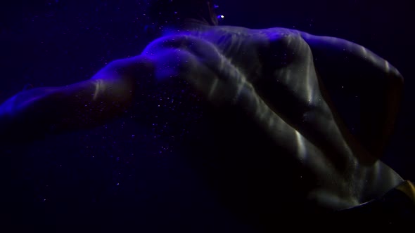 Naked Male Torso in Dark Water of Pool, Man Is Swimming Underwater, Sexy Body