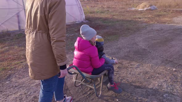 Woman With Children In A Wheelbarrow