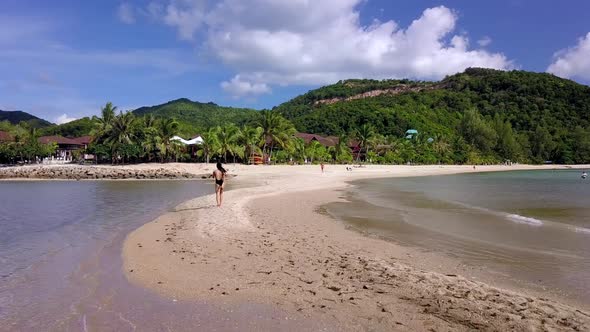 Young Pretty Woman in Black Swimsuit Walking Alone on a SandbarThailand