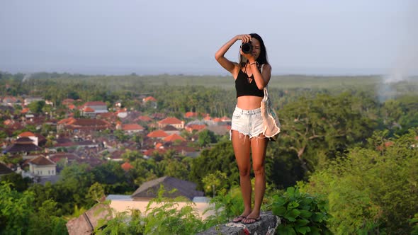 Travel photographer girl taking photos of landscape at sunset,Bali
