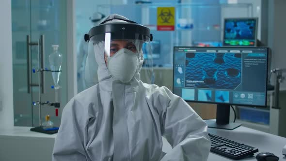 Overworked Woman Chemist in Coverall Looking Tired at Camera