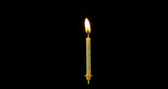 Realistic full-sized single yellow birthday candlelight isolated on black background.