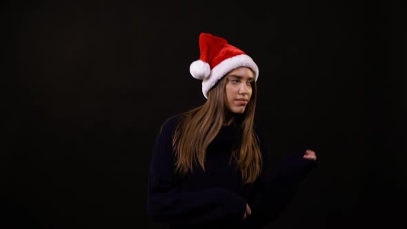 A girl with a Santa hat dancing