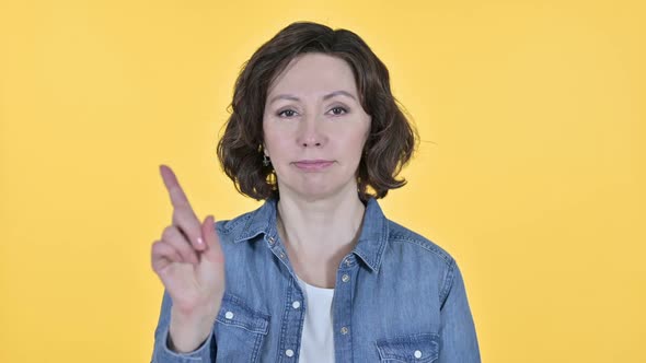 No Finger Sign By Old Woman on Yellow Background