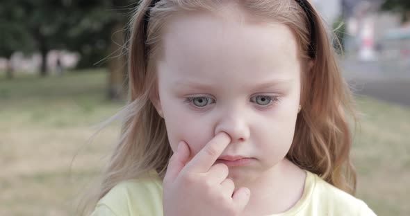 A Pensive Little Girl Picking Her Nose.