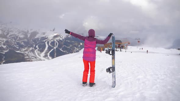 Girl Snowboarder with Snowboard on Mountain Top on Ski Resort. Winter Sports and Winter Vacation