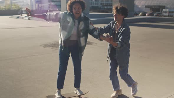 Girl Trying Skateboarding with Friend