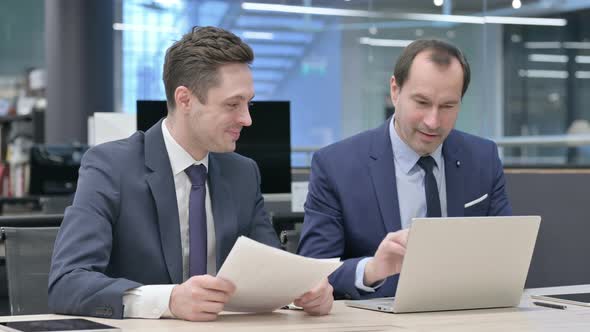 Businessman and Colleague Doing High Five in Office