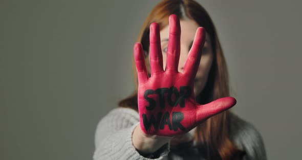 Young Girl Rebels Against War and Says Stop with Written Red Hand