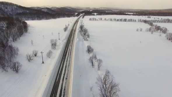 Drone's Camera Show Cars on Traffic During Snow. In Background Fields, Roads.