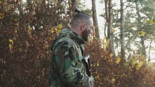 A Soldier Returns to Camera with a Rifle Puts Finger to Lips to Show Silence