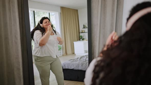 Young Overweight Woman Dances Smiling at Own Reflection