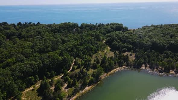 Forward motion over lush trees to show lake Michigan.