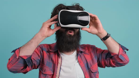 Bearded Man Wearing Virtual Reality Glasses. Studio Shot, Turquoise Background