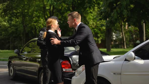 Police Officer Calming Down Aggressive Drivers After Road Accident, Damage