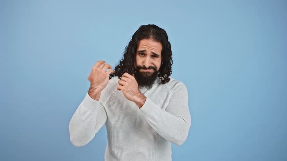 Disappointed Bearded Guy with Long Hair Checking His Hair Condition Looking Displeased with His