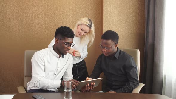 Three People Looking at Touch Screen Computer During Work