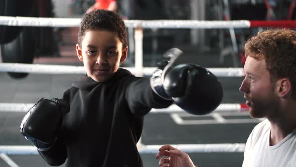 Boy Boxer Practicing Punches with His Coach at Gym