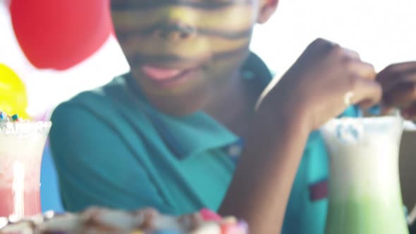 Boy having sweet food and drinks in the playground