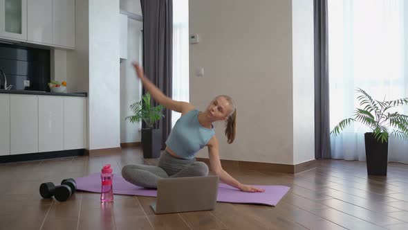 Fit Woman Using Laptop While Stretching Body Home