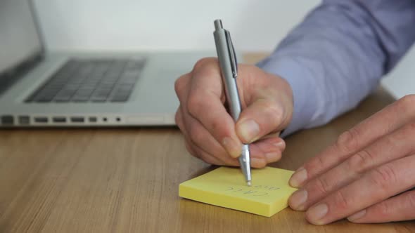 MS, Male writing note and typing on laptop