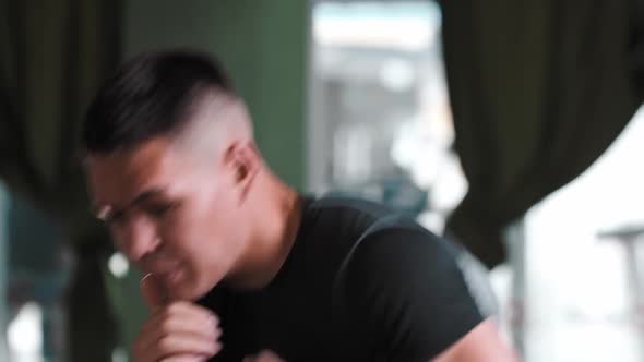 A Man in Sportive Tshirt Shadow Boxing in Front of a Camera