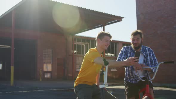 BMX riders sitting in a yard talking