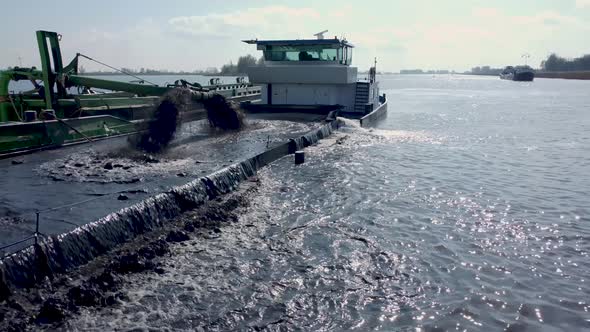 Dredging ship dredges off mud from river bottom to improve the fairway