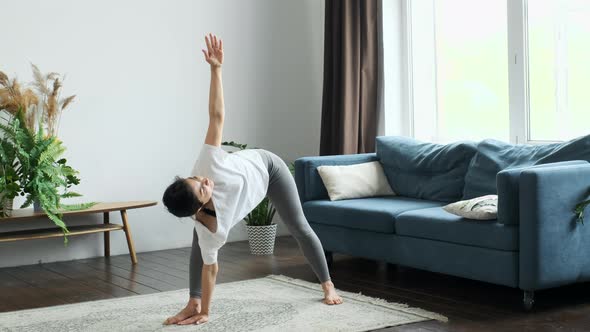 A Young Indian Woman Does Morning Yoga, Does A Body Stretching Exercise, Stands on the Floor