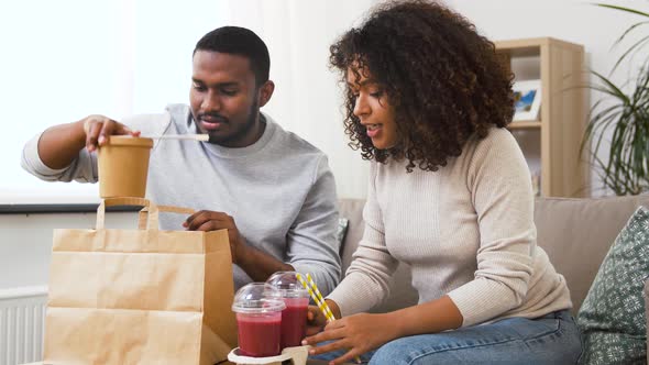Couple with Takeaway Food and Straw Drinks at Home
