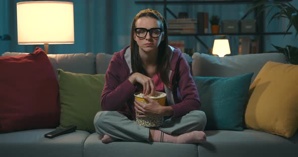 Woman watching TV and eating popcorn