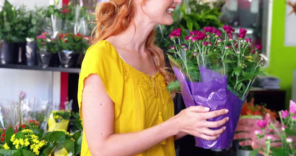 Female florist giving bunch of flower to costumer