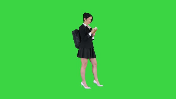 Pretty Student with Backpack Writing Notes on a Green Screen, Chroma Key