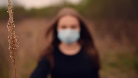 Woman in a Medical Mask Covers Her Face with Dry Reeds Pandemic Covid19 Coronavirus
